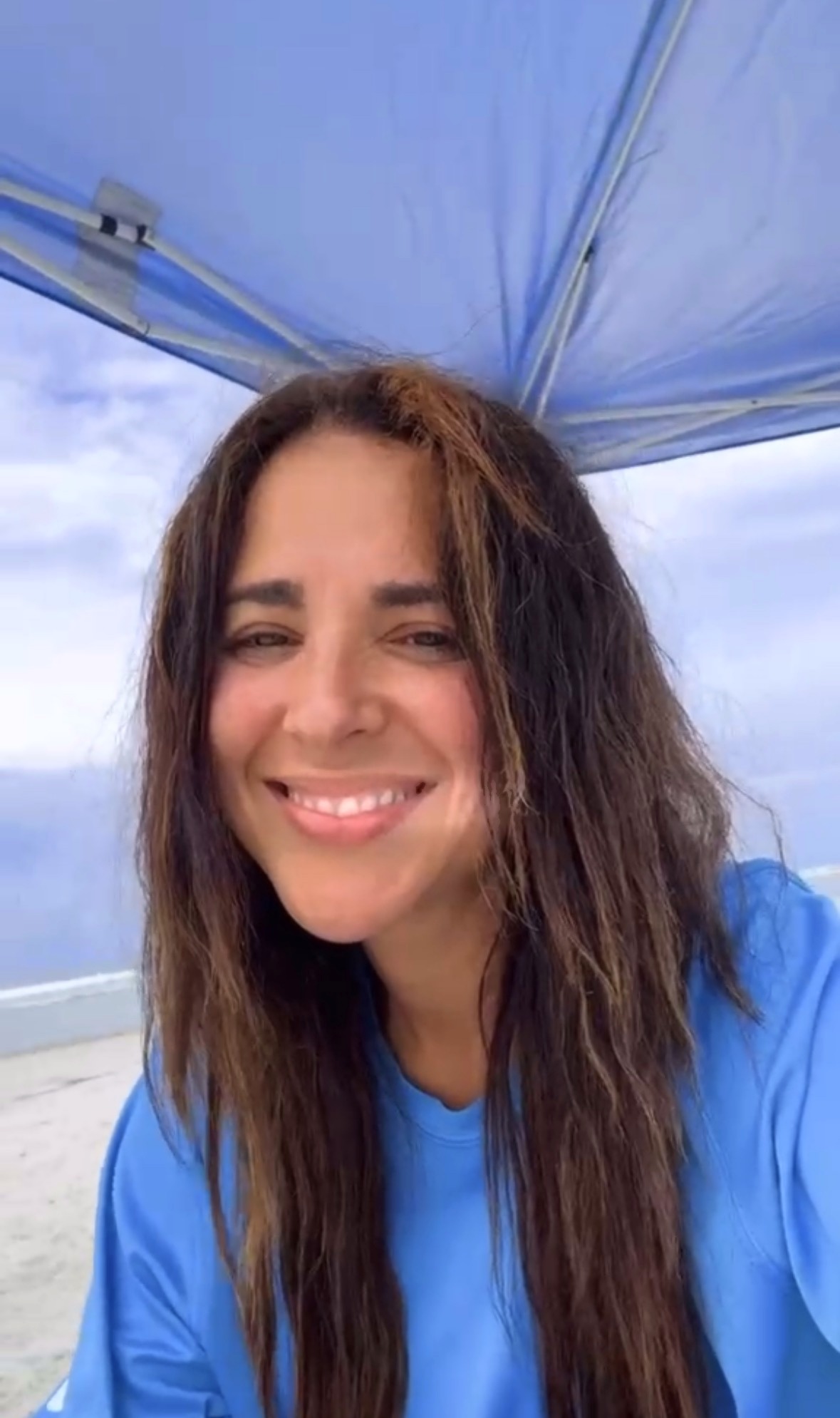 Caro Manzano en la playa con blusa azul