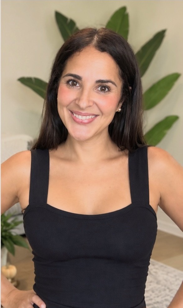 Caro Manzano con top negro, sonriendo en su casa